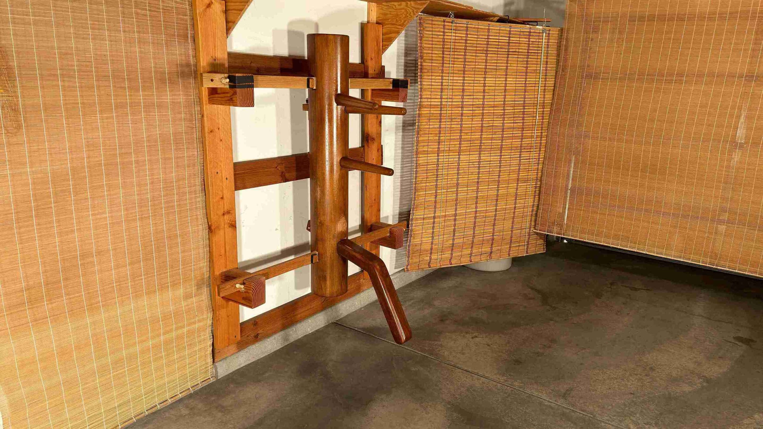 Traditional Wing Chun training hall with wooden dummy and bamboo backdrop